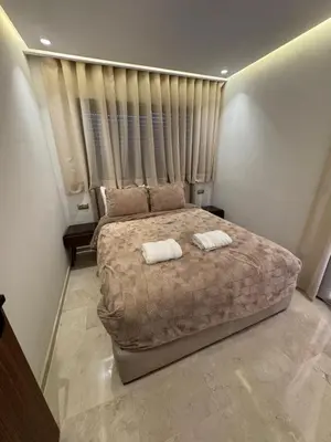 a bedroom with a large bed with two towels on it at Urban Studio Guéliz in Marrakech