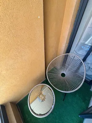 two metal tables and a fan on a green floor at Urban Studio Guéliz in Marrakech