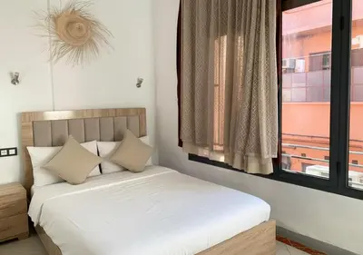 a bedroom with a white bed with a window at Appart Jamaa lafna square in Marrakech