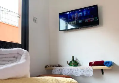 a living room with a tv on the wall at Appart Jamaa lafna square in Marrakech