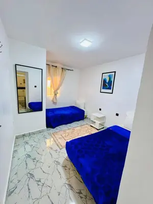 a bedroom with blue beds and a mirror at Mdina Studio- 5 min de la place in Marrakech