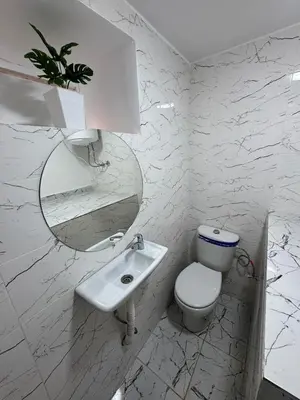 a white bathroom with a toilet and a sink at Mdina Studio- 5 min de la place in Marrakech