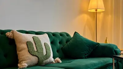 a green couch with a cactus pillow on it at Mosaic 54 - Terrasse & Piscine chauffée - M Avenue in Marrakech