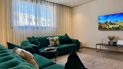 a living room with a green couch and a table at Mosaic 54 - Terrasse & Piscine chauffée - M Avenue in Marrakech