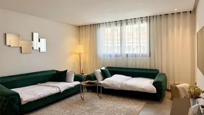 a living room with two green couches and a table at Mosaic 54 - Terrasse & Piscine chauffée - M Avenue in Marrakech