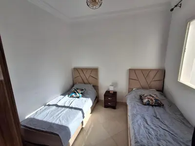 two beds in a small room withermottermottermottermott at Appartement a louer 2 chambres in Marrakech