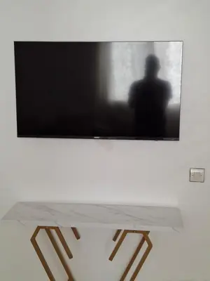 a flat screen tv hanging on a wall with a table at Appartement a louer 2 chambres in Marrakech