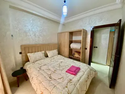 a bedroom with a bed with a pink towel on it at Charmant, terrasse intime, près du centre in Marrakech