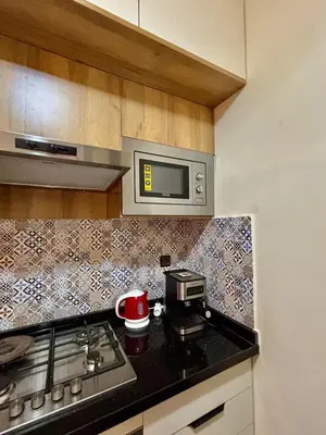 a kitchen with a stove and a microwave at Charmant, terrasse intime, près du centre in Marrakech