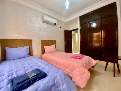 a bedroom with two beds with pink and purple sheets at Charmant, terrasse intime, près du centre in Marrakech
