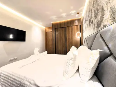 a bedroom with a white bed with a wooden headboard at Luxury & Modern Style 1BR, Gueliz-Steps from train in Marrakech