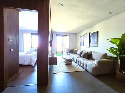 a living room with a couch and a bed at Luxury & Modern Style 1BR, Gueliz-Steps from train in Marrakech