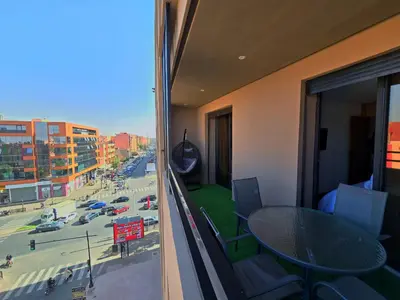 a balcony with a table and a view of a street at Luxury & Modern Style 1BR, Gueliz-Steps from train in Marrakech