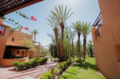 a courtyard of a house with palm trees at Traditional, Cozy and Quiet Apartment, Pool, Palmeraie in Marrakech