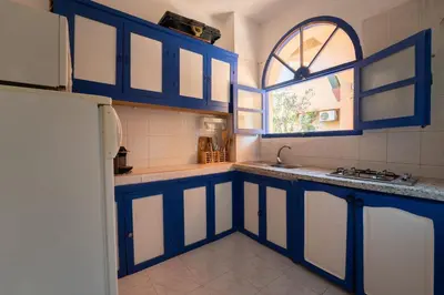 a kitchen with blue cabinets and a window at Traditional, Cozy and Quiet Apartment, Pool, Palmeraie in Marrakech