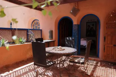 a patio with a table and chairs in a house at Traditional, Cozy and Quiet Apartment, Pool, Palmeraie in Marrakech
