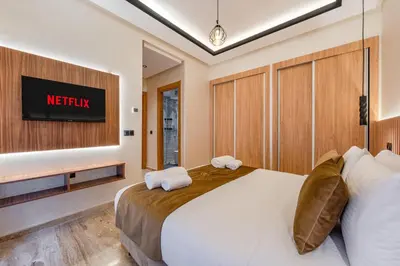 a bedroom with a bed and a tv on a wall at Guéliz 7 Appartements in One Building in Marrakech
