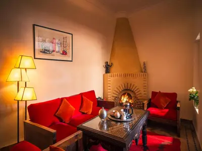 a living room with a red couch and a fireplace at Riad Darhani - Private use option - in Marrakech