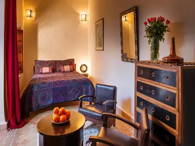 a bedroom with a bed and a table with a bowl of fruit at Riad Darhani - Private use option - in Marrakech