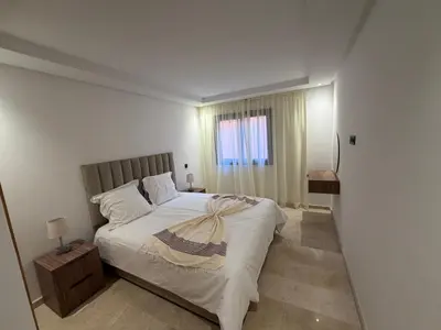 a bedroom with a large bed and a window at Appartement duplex haut standing Guelyz in Marrakech