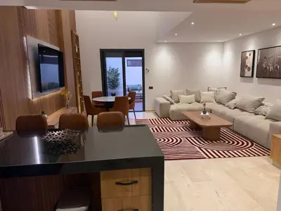 a living room with a couch and a table at Appartement duplex haut standing Guelyz in Marrakech