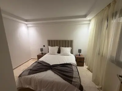 a bedroom with a bed with a bow tie on it at Appartement duplex haut standing Guelyz in Marrakech