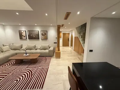 a living room with a couch and a table at Appartement duplex haut standing Guelyz in Marrakech