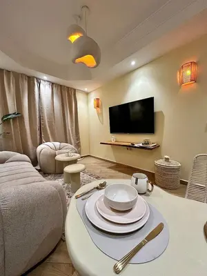 a living room with a table with plates on it at Downtown Feng Shui-style apartment with mountain view in Marrakech