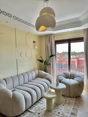 a living room with a large couch and two tables at Downtown Feng Shui-style apartment with mountain view in Marrakech