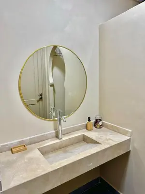 a bathroom with a sink and a mirror at Downtown Feng Shui-style apartment with mountain view in Marrakech