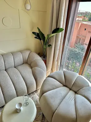 a living room with a couch and a table and a window at Downtown Feng Shui-style apartment with mountain view in Marrakech
