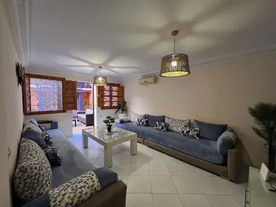 a living room with a blue couch and a table at Le Patio Marrakchi in Marrakech