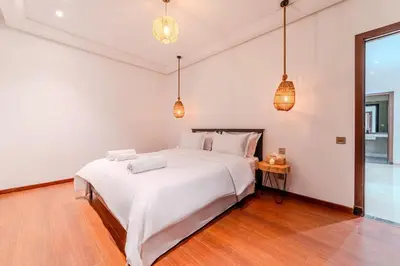 a bedroom with a large white bed and pendant lights at New Luxury Downtown Apart Marrakech 3BR Terraces in Marrakech