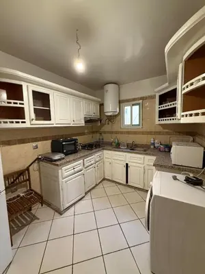 a kitchen with white cabinets and a white tile floor at Modern Flat Gueliz ,City center Marrakech in Marrakech