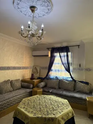 a living room with a couch and a chandelier at Modern Flat Gueliz ,City center Marrakech in Marrakech