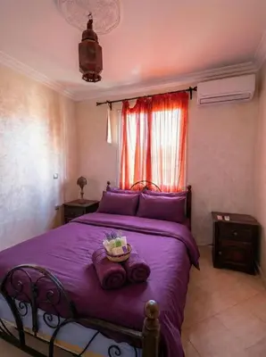 a bedroom with a purple bed with a basket on it at Modern Flat Gueliz ,City center Marrakech in Marrakech
