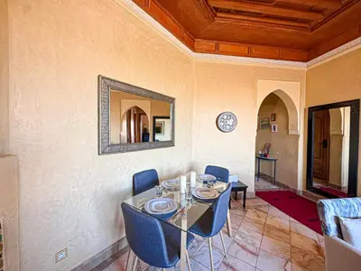 a dining room with a table and chairs and a mirror at Oasis Palmeraie - Piscines & terrasses in Marrakech