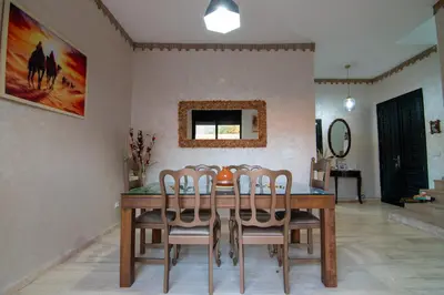 a dining room with a wooden table and chairs at Villa Familiale, Piscine et jardin privés, proche du centre ville in Marrakech