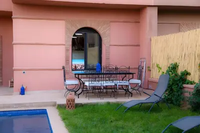 a patio with a table and chairs next to a pool at Villa Familiale, Piscine et jardin privés, proche du centre ville in Marrakech