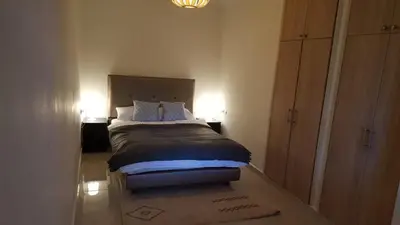 a bedroom with a bed with two lamps and a dresser at Étoile de marrakech in Marrakech