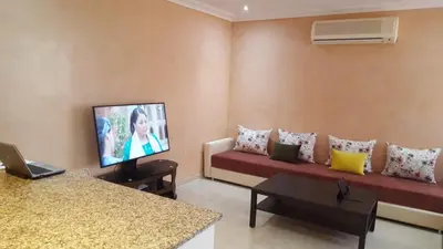 a living room with a couch and a flat screen tv at Étoile de marrakech in Marrakech