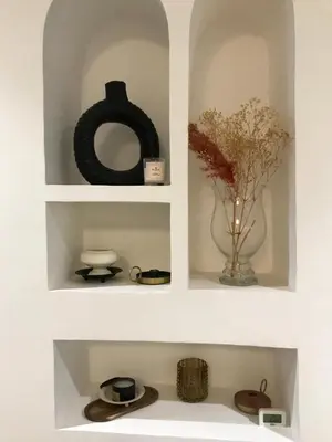 two white shelves with a vase with flowers in it at Résidence avec piscine &salle de sport a la palmeraie À 10minutes du Madina Marrakech in Marrakech