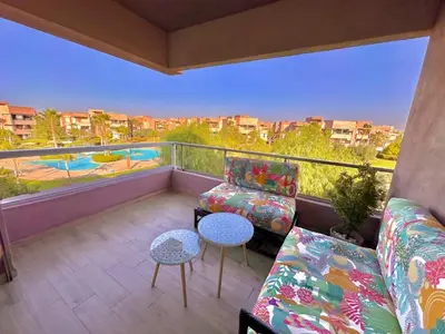 a balcony with couches and a view of a pool at Luxury Apartments in Marrakech
