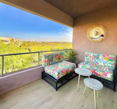 a balcony with two chairs and a table and a window at Luxury Apartments in Marrakech