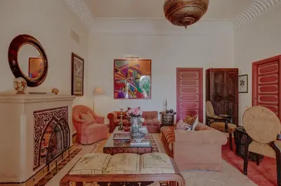 a living room with pink furniture and a fireplace at Casa Memoria Marrakech in Marrakech
