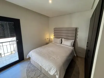 a bedroom with a white bed with a window at Modern apartment in Gueliz Plaza in Marrakech