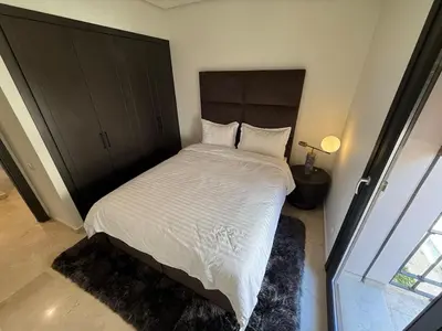 a bedroom with a large bed with white sheets and pillows at Modern apartment in Gueliz Plaza in Marrakech