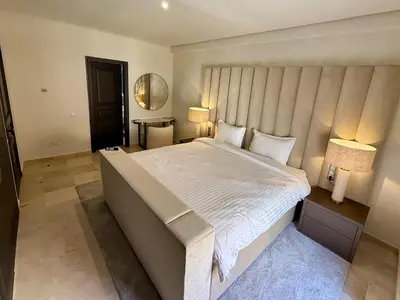 a bedroom with a large white bed with two lamps at Modern apartment in Gueliz Plaza in Marrakech
