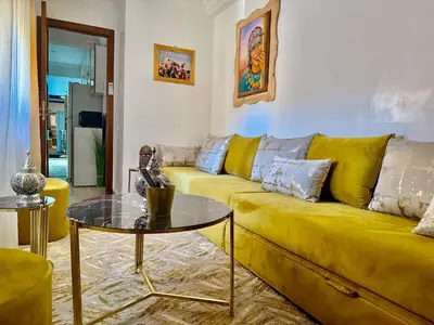 a yellow couch in a living room with a table at Moroccan style Soltana pool & central internet in Marrakech