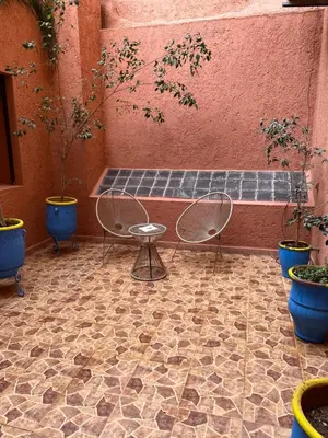 a patio with chairs and potted plants and a bench at Apartment in Gueliz in Marrakech